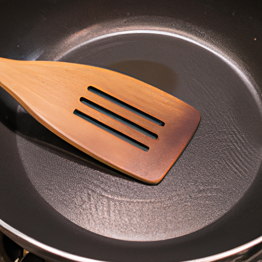 A close-up of a non-stick frying pan with a wooden spatula.